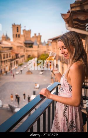 Junge blonde weiße Frau in einem langen rosafarbenen Kleid, die ein wunderschönes Landhotel in der Stadt Olite in Navarra genießt. Spanien, ländlicher Lebensstil. Mit einem Stockfoto