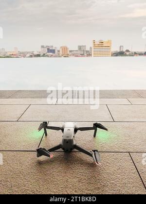 Melaka, Malaysia - 9. Juli 2023 DJI Air 2S Drohne startbereit in der Nähe des Schwimmbades mit Blick auf die Stadt Malakka. Stockfoto