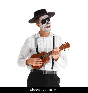 Junger Mann mit bemaltem Schädel, der Gitarre auf weißem Hintergrund spielt. Mexikanischer Tag der Toten (El Dia de Muertos) Stockfoto