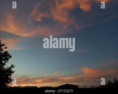 Wunderschöne, verschwommene Wolken am blauen Himmel eines Sonnenuntergangs am Horizont. Stockfoto