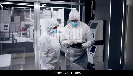 Sterile Halbleiterfabrik Und Arbeiter In Overalls Stockfoto