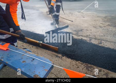 Straßenerneuerung. Frische Asphaltkonstruktion. Arbeiter, die die Straße reparieren. Auckland. Stockfoto