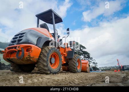 Planierraupe arbeitet an einem Sandstrand. Stockfoto