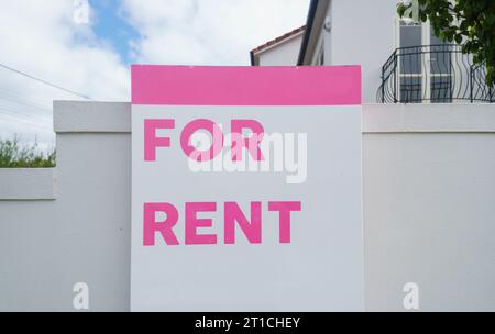 Hausschild vor dem Haus an der weißen Zaunwand. Stockfoto