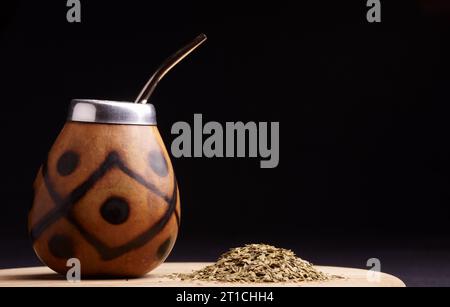 Traditioneller südamerikanischer Yerba Mate Tee im Calabash Circle und Bombilla. Schwarzer Hintergrund. Nahaufnahme. Stockfoto