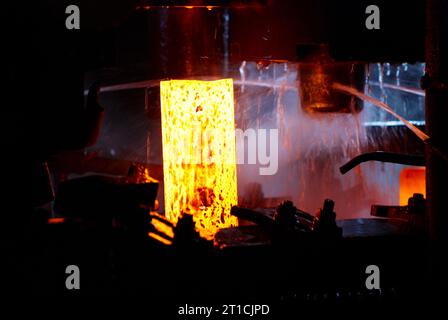 Metallschmieden. Hydraulischer Hammer formt das rot heiße Billet. Die Produktion von High-Tech-Teilen. Stockfoto