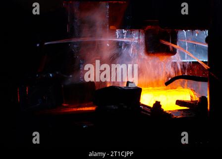 Metallschmieden. Hydraulischer Hammer formt das rot heiße Billet. Die Produktion von High-Tech-Teilen. Stockfoto