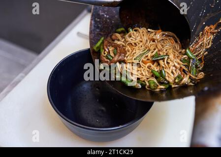 Zubereitung frittierte Nudeln mit Gemüse im Wok, traditionelle asiatische Küche. Stockfoto