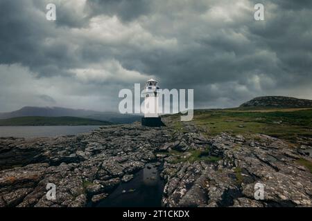 Rhue Lighthouse ist ein weißer Leuchtturm an der Küste von Loch Broom in der Nähe von Ullapool in Schottland. Stockfoto