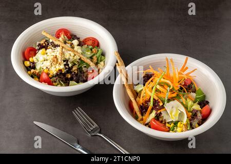 Salat mit Karotten, Tomaten, Mais und viel Gemüse auf weißen Porzellanplatten Stockfoto