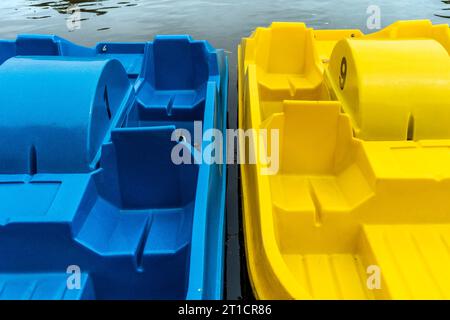 Blaue und gelbe Tretboote können auf dem Trenance Boating Lake in Newquay in Cornwall im Vereinigten Königreich gemietet werden. Stockfoto