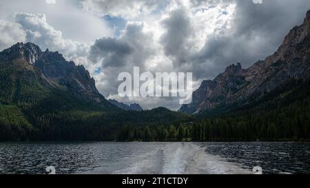 Ein ruhiger See, umgeben von üppigen Bäumen, mit einem kleinen Boot, das im Hintergrund ankert Stockfoto