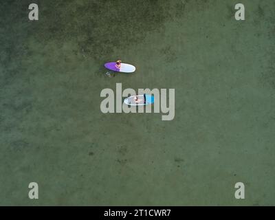 Blick von oben auf SUP-Boards auf dem flachen türkisfarbenen Wasser des Asowschen Meeres, Ukraine Stockfoto