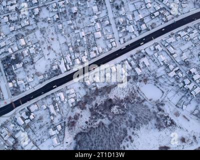 Straße durch das Dorf im Winter. Luftaufnahme. Stockfoto