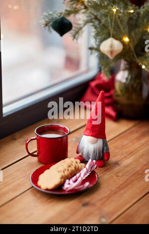 weihnachtszwerg, Kaffee und Kekse auf der Fensterbank Stockfoto