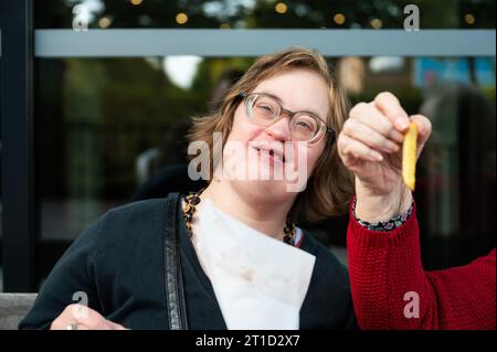 Frau mit Down-Syndrom isst Pommes frites mit ihrer 85-jährigen Mutter, Tienen, Flandern, Belgien Stockfoto