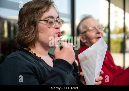 Frau mit Down-Syndrom isst Pommes frites mit ihrer 85-jährigen Mutter, Tienen, Flandern, Belgien Stockfoto