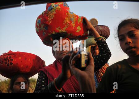 Shivpiri, Madhya Pradesh, Indien. Oktober 2023. Eine Frau und ihre Kinder kehren am Abend nach der Landwirtschaft nach Hause.at auf der National Highway of Shivpuri, Madhya Pradesh, 400 Meilen von der National Capital New Delhi entfernt, am Donnerstag 12.10.2023 Foto von Ravi Batra (Credit Image: © Ravi Batra/ZUMA Press Wire) NUR REDAKTIONELLE VERWENDUNG! Nicht für kommerzielle ZWECKE! Stockfoto
