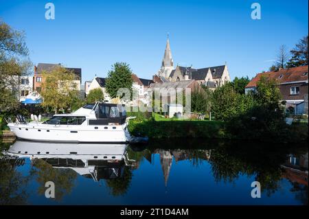 Liedekerke, Ostflämische Region, Belgien, 1. Oktober, 2023: Schiff, Häuser und Bäume spiegeln sich im Fluss Dender Stockfoto
