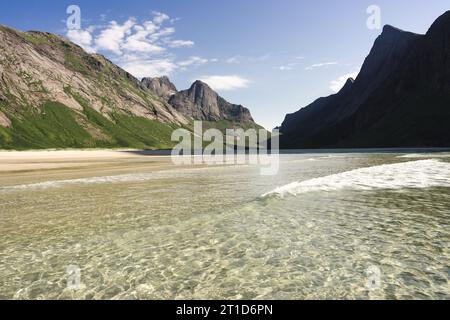 Klare Meereswellen, die am Strand unter den Klippen krachen Stockfoto