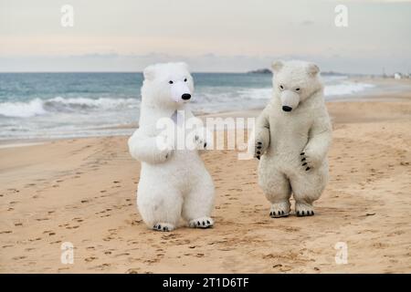 Animateure, die als Eisbären verkleidet sind, unterhalten die Leute am Strand Stockfoto