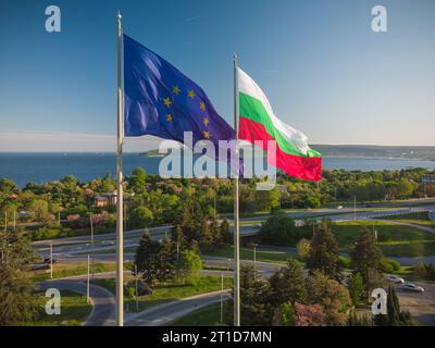 Die Flagge der Europäischen Union und Bulgariens gegen die Stadt Varna und den blauen Himmel am Sommertag Stockfoto
