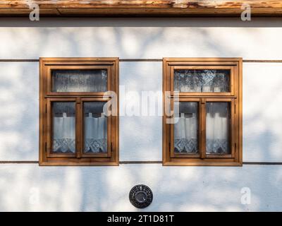 Traditionelle Holzfenster und handgefertigte Vorhänge in einem Dorf in Ungarn, Holloko Stockfoto