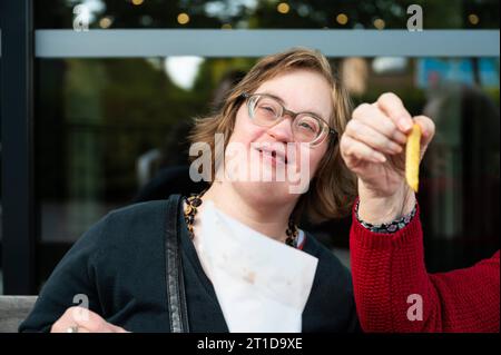 Frau mit Down-Syndrom isst Pommes frites mit ihrer 85-jährigen Mutter, Tienen, Flandern, Belgien Stockfoto