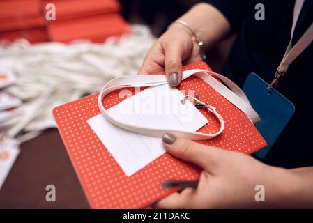 Prozess des Eincheckens bei Veranstaltung des Kongressforums, bei der Registrierung, bei Besuchern und Teilnehmern, die ein Namensschild erhalten. Stockfoto