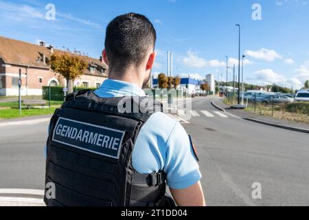 Polizeibeamter („Gendarme“), der eine Straßenkontrolle an einem Kreisverkehr durchführt Stockfoto