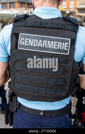 Polizeibeamter („Gendarme“), der eine Straßenkontrolle an einem Kreisverkehr durchführt Stockfoto