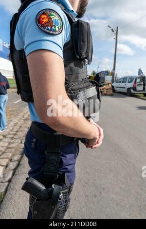 Polizeibeamter („Gendarme“), der eine Straßenkontrolle an einem Kreisverkehr durchführt Stockfoto