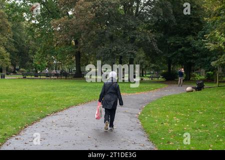 Windsor, Berkshire, Großbritannien. Oktober 2023. Eine Dame läuft durch Alexandra Gardens. Es war ein langweiliger und nasser Tag heute in Windsor, Berkshire. Quelle: Maureen McLean/Alamy Live News Stockfoto