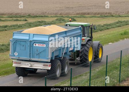 Weizenernte im Sommer im Département Loiret (Nord-Mittelfrankreich). Traktoren, die Weizen an eine Kooperative liefern, Silos und Lagerplattform, Traktortraktion Stockfoto