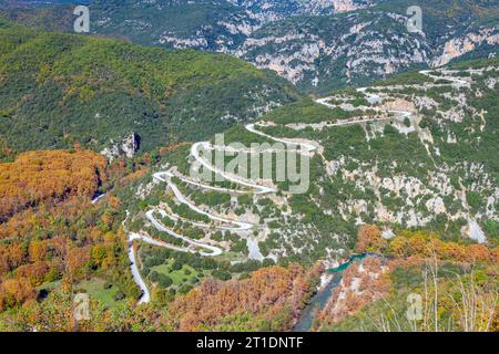 Herbstlicher Blick auf die zahlreichen Kurven der Straße in Richtung Papigko Dorf, in der malerischen Bergregion Zagori, in Epirus, Griechenland. Stockfoto