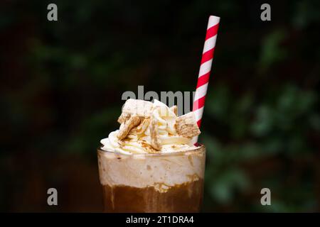 Nahaufnahme von Eiskaffee mit Zimt-Schlagsahne und Strohhalm Stockfoto