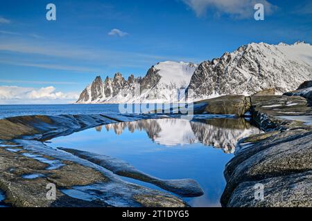 Teufelszähne spiegeln sich in Gezeitenbecken, Ersfjord, Okshornan, Tungeneset, Senja, Troms og Finnmark, Norwegen Stockfoto