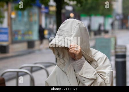 Frau mit Kapuze an einem regnerischen Tag in Preston, Lancashire. Wetter in Großbritannien. Oktober 2023 Stockfoto