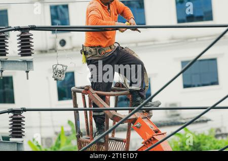 Wartung der Hochspannungsleitung. Elektriker bei der Arbeit. Elektrotechniker, der das Kabel repariert. Hochspannungs-Netzkonstruktion. Gefahr Stockfoto