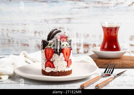 Erdbeere und Kekskuchen. Frischer Kuchen mit Sahne und Erdbeeren auf einem Teller Stockfoto