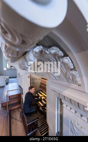 13. Oktober 2023, Sachsen, Leipzig: Markus Kaufmann, Nikolaikantor, sitzt an der Ladegast-Orgel der Nikolaikirche in Leipzig. Im Oktober 2024 jährt sich die Einweihung der renovierten und restaurierten Orgel zum 20. Mal. Der Schwerpunkt liegt seit 2004 auf der Orgelkonsole. In ihren intensiven Bemühungen, das Instrument zu restaurieren, die Pfarrei St. Nikolai erhielt große Unterstützung von Porsche Leipzig. Gemeinsam mit den Orgelbauern der Firma Eule und den Automobildesignern wurde eine Symbiose entwickelt und konzipiert. Das Instrument, das derzeit mit 6822 Rohren und 103 Timbres ausgestattet ist, wird sein Stockfoto