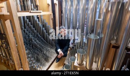 13. Oktober 2023, Sachsen, Leipzig: Markus Kaufmann, Nikolaikantor, wirft einen Blick in die Ladegast-Orgel in der Nikolaikirche in Leipzig. Im Oktober 2024 jährt sich die Einweihung der renovierten und restaurierten Orgel zum 20. Mal. Der Schwerpunkt liegt seit 2004 auf der Orgelkonsole. In ihren intensiven Bemühungen, das Instrument zu restaurieren, die Pfarrei St. Nikolai erhielt große Unterstützung von Porsche Leipzig. Gemeinsam mit den Orgelbauern der Firma Eule und den Automobildesignern wurde eine Symbiose entwickelt und konzipiert. Das Instrument ist derzeit mit 6822 Rohren und 103 Timbr ausgestattet Stockfoto