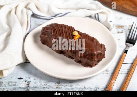 Schokolade und Erdnusskuchen. Erdnusskuchen mit frischer Karamellfüllung auf einem Teller Stockfoto