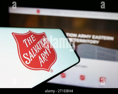 Handy mit Logo der protestantischen Wohltätigkeitsorganisation The Salvation Army (TSA) vor der Website. Konzentrieren Sie sich auf die Mitte des Telefondisplays. Stockfoto