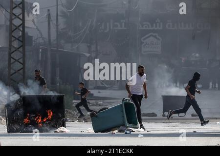 Nablus, Palästinensische Gebiete. Oktober 2023. Palästinensische Demonstranten verbrennen Container und blockieren Straßen während einer Demonstration in der Al-Quds-Straße östlich von Nablus. Neun Menschen seien bei neuen Zusammenstößen an mehreren Orten im Westjordanland getötet worden, sagten die Palästinenser am Freitag. Quelle: Ayman Nobani/dpa/Alamy Live News Stockfoto