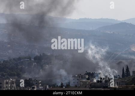 Nablus, Palästinensische Gebiete. Oktober 2023. Eine Luftaufnahme zeigt eine Szene des Chaos und der Zerstörung, während Rauch von brennenden Reifen und Gasbomben über Demonstranten strömt, die israelische Truppen in der Al-Quds-Straße östlich von Nablus konfrontieren. Neun Menschen seien bei neuen Zusammenstößen an mehreren Orten im Westjordanland getötet worden, sagten die Palästinenser am Freitag. Quelle: Ayman Nobani/dpa/Alamy Live News Stockfoto