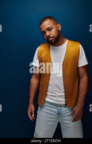 Stilvoller bärtiger afroamerikaner mit gelber Weste und Blick in die Kamera, Modekonzept Stockfoto