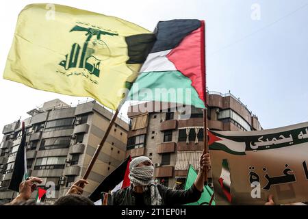 Beirut, Libanon. Oktober 2023. Libanesische Demonstranten tragen in Solidarität mit den Palästinensern die Hisbollah- und palästinensische Fahnen, während die Kämpfe zwischen israelischen Truppen und Militanten der palästinensischen Gruppe Hamas fortgesetzt werden. Marwan Naamani/dpa/Alamy Live News Stockfoto