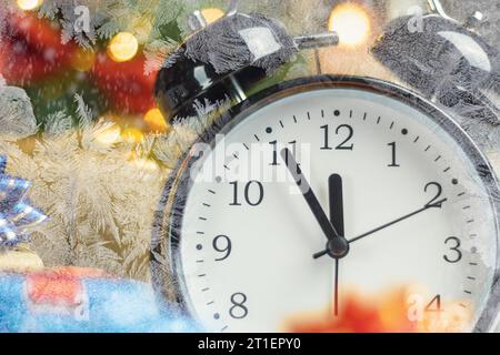 Der Wecker zeigt an, dass es in fünf Minuten zwölf Uhr ist, das neue Jahr. Fünf Minuten bis zwölf, Silvester. Nahaufnahme. Neujahr b Stockfoto