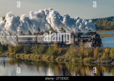 HELYULYA, RUSSLAND - 06. OKTOBER 2023: Retro-Zug „Ruskeala Express“ auf dem Staudamm des Kalmaranyarvi-Sees an einem Oktobertag in Karelien Stockfoto